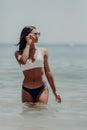 Young latin woman in bikini walking in the water along the beach Royalty Free Stock Photo