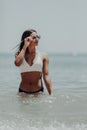 Young latin woman in bikini walking in the water along the beach Royalty Free Stock Photo