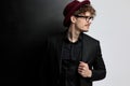 Young sexy man fixing his jacket, wearing a burgundy hat Royalty Free Stock Photo