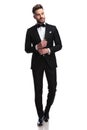 Young man in tuxedo and bowtie fixing his sleeve Royalty Free Stock Photo