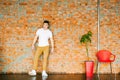 Young men bodybuilder athlete,studio portrait in loft, guy model in white T-shirt and brown trousers