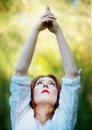 Young sexy redhead woman doing the yoga tree pose, Utthita vrksasana, in nature in the sun Royalty Free Stock Photo