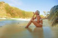 Young sexy and relaxed blond woman in bikini sitting on the sand looking at sea enjoying summer holidays at beautiful tropical Royalty Free Stock Photo