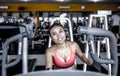 and sweaty Asian woman training hard at gym using elliptical pedaling machine gear in intense workout Royalty Free Stock Photo