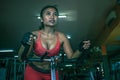 Young and sweaty Asian woman training hard at gym using elliptical pedaling machine gear in intense workout exercise Royalty Free Stock Photo