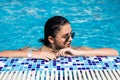 Young sexy woman in bikini wearing sunglasses relax in water at swimming pool