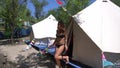 Young sexy woman in black bikini getting out from big white tent in summer at the glamping area