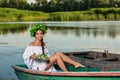 Young woman on boat at sunset. The girl has a flower wreath on her head, relaxing and sailing on river. Fantasy art