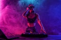 Young sexy woman dj playing music. Headphones and dj mixer on table. Royalty Free Stock Photo