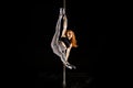 Young and woman exercises pole dance on the dark background Royalty Free Stock Photo