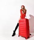 Young woman in fashion red body cloth and hat with holiday traveler luggage bag on white