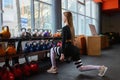 Young sexy woman during fitness workout at gym. Exercises with dumbbells. Squats and lunges. Royalty Free Stock Photo