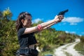 Young sexy woman hunter wearing top and shorts holding a gun