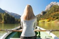 Woman is rowing with a rowing boat with a lake in the mountains Royalty Free Stock Photo