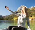 Woman is rowing with a rowing boat with a lake in the mountains Royalty Free Stock Photo