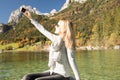 Woman is rowing with a rowing boat with a lake in the mountains Royalty Free Stock Photo