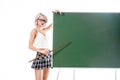young sexy woman in school skirt pointing at empty chalkboard with pointer