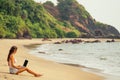 Young sexy woman in stylish glasses using laptop freelancing on the tropical paradise beach. Girl freelancer work Royalty Free Stock Photo