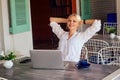 Young sexy woman in a stylish shirt using laptop and telephone freelancing on the tropical paradise beach. Girl cup tea Royalty Free Stock Photo