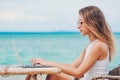 Young woman using laptop on the beach. Freelance work