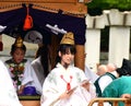 Young shinto priestess distributing good luck charms during Aoba festival