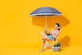 Young shirtless Asian man sitting on beach chair relaxing and listening to music in  summer yellow background Royalty Free Stock Photo