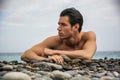 Young shirtless athletic man laying down on pebbles Royalty Free Stock Photo