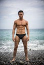 Young shirtless athletic man standing in water by ocean shore Royalty Free Stock Photo