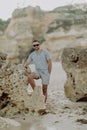 Young man on the beach, man walking on the rocky beach coastline