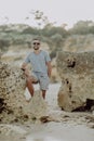 Young man on the beach, man walking on the rocky beach coastline