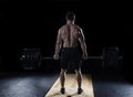 Young shirtless man doing deadlift exercise at the gym.