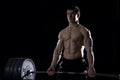 Young shirtless man doing deadlift exercise at the gym.