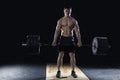 Young shirtless man doing deadlift exercise at the gym.