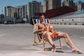 young shirtless man relaxing on sun lounger with cocktail and using smartphone Royalty Free Stock Photo