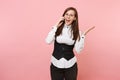 Young shocked amazed business woman in glasses holding talking on mobile phone spreading hands on pastel pink Royalty Free Stock Photo