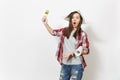 Young shocked beautiful woman in casual clothes and newspaper hat holding paint brush and wallpaper roll isolated on Royalty Free Stock Photo