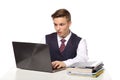 Young shocked businessman calculates taxes at desk in office. Isolated on white