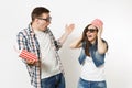 Young shocked couple, woman and man in 3d glasses with bucket for popcorn on head watching movie film on date, holding Royalty Free Stock Photo