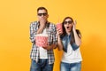 Young shocked couple woman man in 3d glasses watching movie film on date holding bucket of popcorn cup of soda or cola Royalty Free Stock Photo