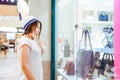 Young shocked girl looking at shop window with shoes and bags in Shopping Mall. Shopper. Sales. Shopping Center. Space for text. S Royalty Free Stock Photo