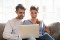 Young shocked surprised couple using laptop together at home Royalty Free Stock Photo