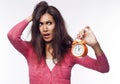 Young shocked woman holding clocks in hands