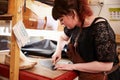 Young shoemaker cutting leather in a workshop