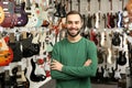 Shop assistant near guitars in music store Royalty Free Stock Photo