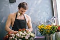 Young shop assistant selecting best flowers for sale