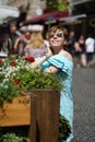 Young shorthair caucsian woman in blue dress and suglasses smiling while walking in sunny street Royalty Free Stock Photo