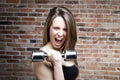 Young shouting fit woman lifting dumbbells