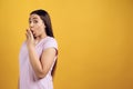 Young shy girl covers mouth with palm.