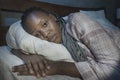 Young sick and depressed black afro American woman lying on bed at home unhappy and sleepless at night feeling overwhelmed Royalty Free Stock Photo