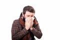 Young sick and ill man in bed holding tissue cleaning snotty nose having temperature feeling bad infected by winter Royalty Free Stock Photo